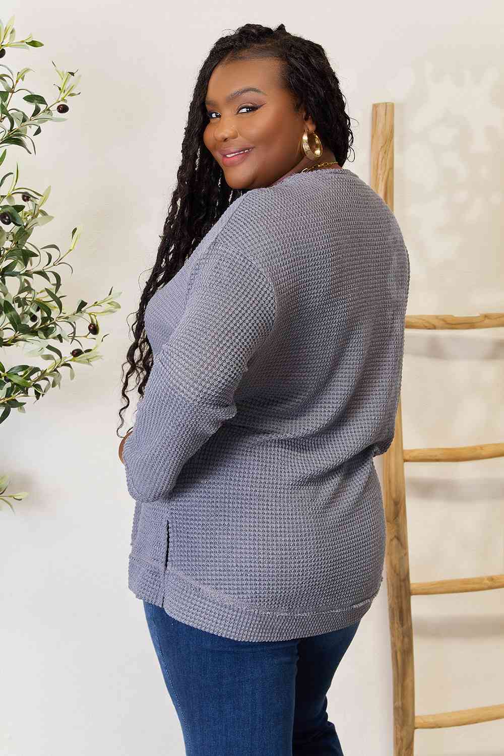 The waffle-knit round neck long sleeve slit sweatshirt is a cozy and stylish addition to any wardrobe.