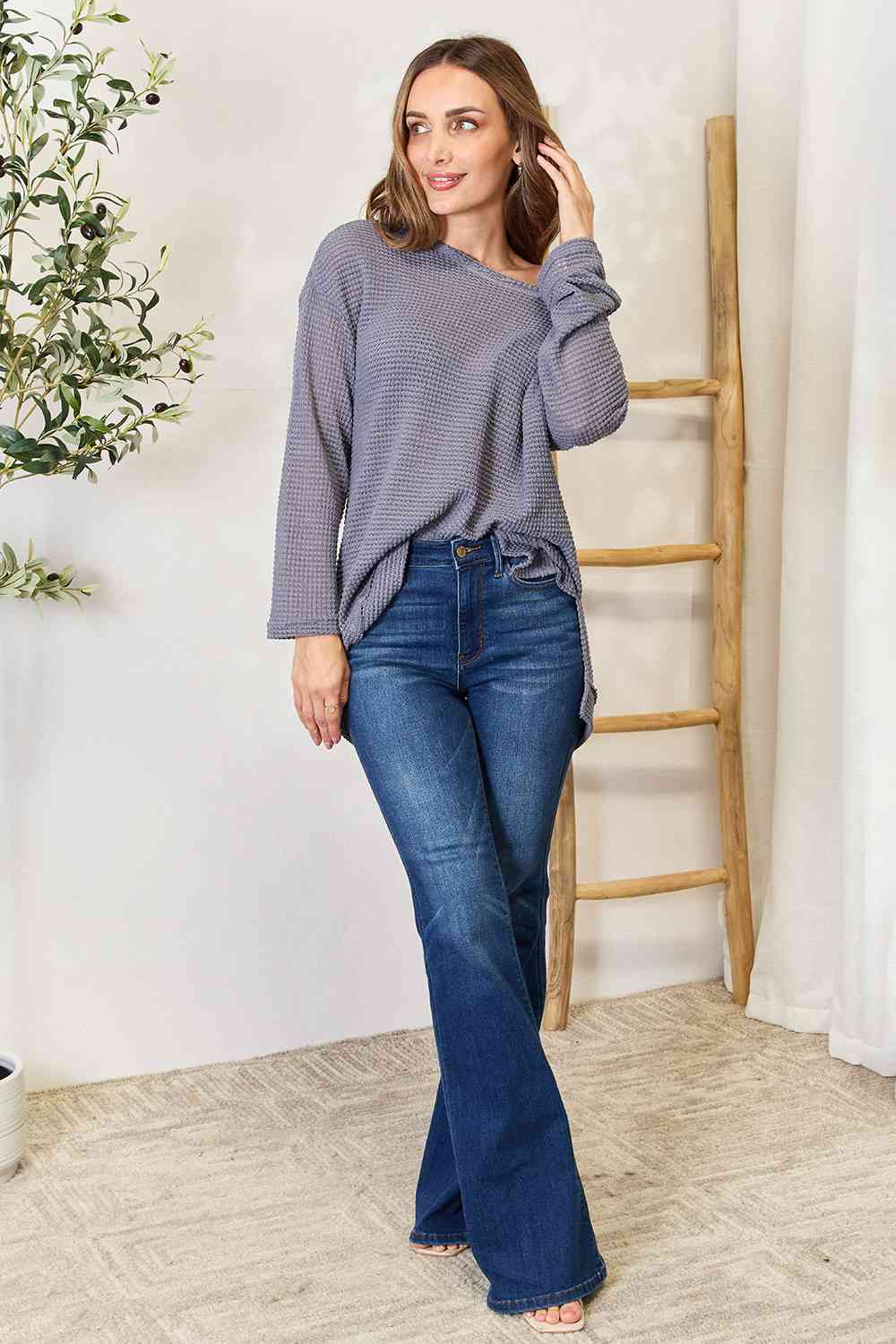 The waffle-knit round neck long sleeve slit sweatshirt is a cozy and stylish addition to any wardrobe.